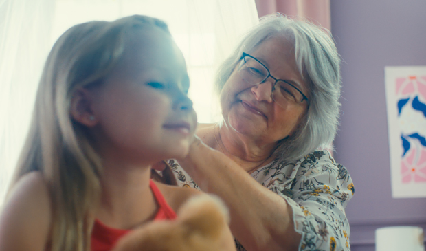 A grandma brushing her granddaughter's hair