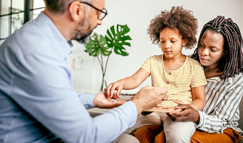 Physician, child and mother interacting